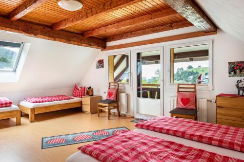 a room with two beds and a couch and windows at Sport Rees - Ferienwohnung Anna in Hofsgrund