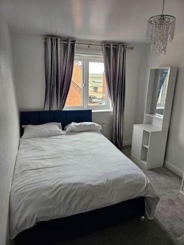a bedroom with a large bed and a window at Relaxing Townhouse in Derby