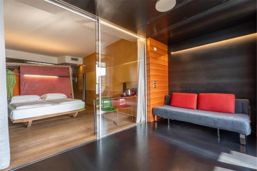 a bedroom with a bed and a couch and a mirror at Ambienthotel PrimaLuna 3S in Malcesine