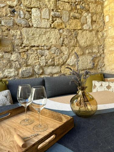 deux verres à vin et un vase sur une table dans l'établissement La Maison du Clocher, à Saint-Émilion