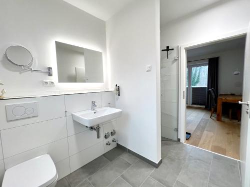 a white bathroom with a toilet and a sink at Apartmenthaus Emily by POLY Hohwacht in Hohwacht