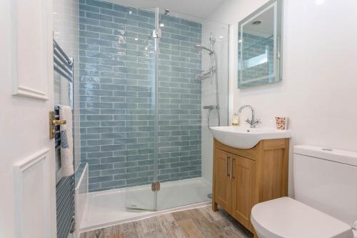 a bathroom with a sink and a glass shower at The Crows Nest - Apartment with great sea views- Crabpot Cottages Sheringham in Sheringham