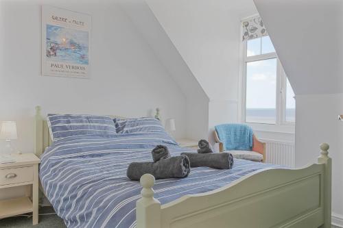 a bedroom with a bed with two teddy bears on it at The Crows Nest - Apartment with great sea views- Crabpot Cottages Sheringham in Sheringham