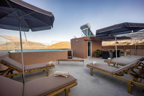 a patio with chairs and umbrellas on a roof at Luxury apartment with rooftop pool in Meronas in Méronas