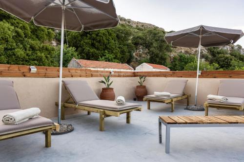a group of chairs and umbrellas on a patio at Luxury apartment with rooftop pool in Meronas in Méronas