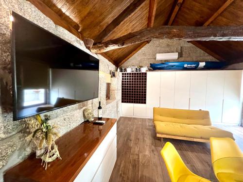 a living room with yellow chairs and a tv at Wine Press INN in Amarante