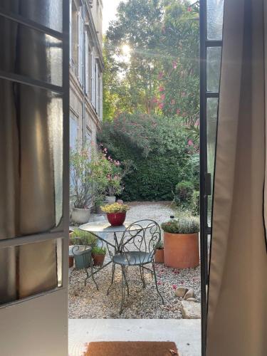 an open door to a patio with a table and chairs at Le Jardin des Etudes - Terrasse - Mansion 300 years in Avignon