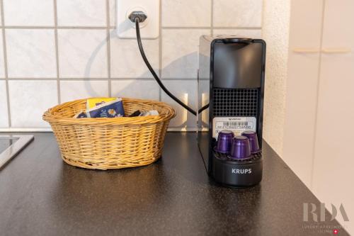 a black counter top with a basket and a black appliance at il Tempio 250m dal lago RDA Lux AP in Mendrisio