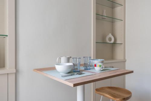 une table avec des bols et des verres sur une étagère dans l'établissement Appartement Hermosa - Welkeys, à Paris