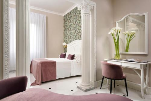 a bedroom with a bed and a desk and a mirror at Hotel President in Viareggio