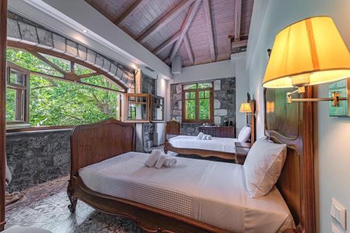 a bedroom with two beds and a large window at ΤΕΓΟΣ Country Guest House in Tripolis