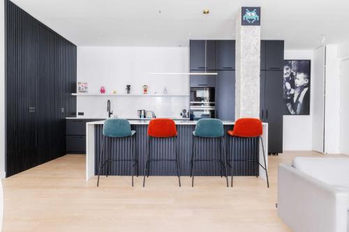 une cuisine avec un comptoir avec quatre tabourets dans l'établissement Magnificent apartment - 3BR-6P - Europe, à Paris