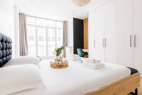 une chambre blanche avec un grand lit blanc et une fenêtre dans l'établissement Magnificent apartment - 3BR-6P - Europe, à Paris