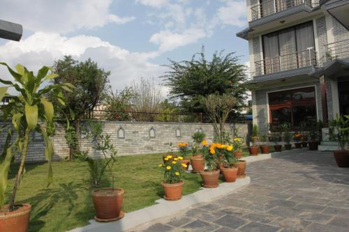 a row of potted plants in front of a house at Hotel Pokhara View in Pokhara