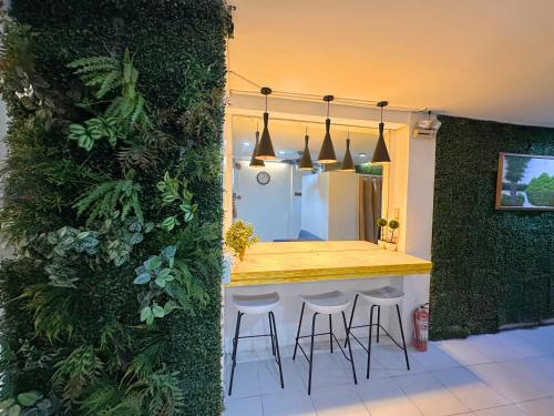 a kitchen with a counter with stools and a refrigerator at Dormitelsph España in Manila