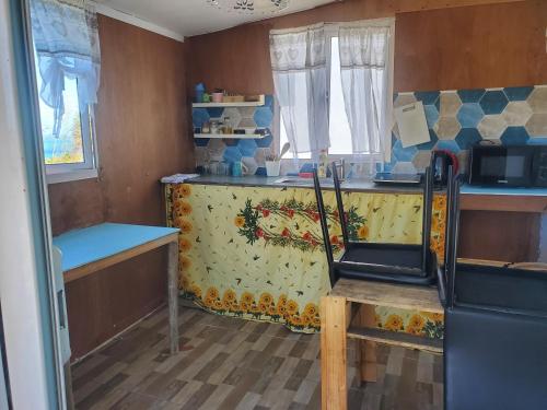 eine kleine Küche mit Theke und Mikrowelle in der Unterkunft Petite maison de tôle Rodriguaises in Tambe