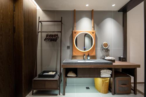 a bathroom with a sink and a mirror at Presidential Palace YiLi Hotel Nanjing in Nanjing