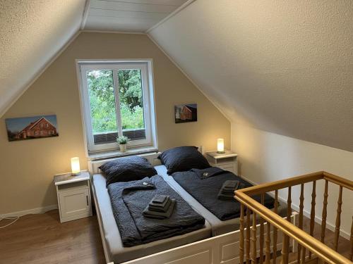 a bedroom with a bed with pillows and a window at !!!NEU!!! FEWO Sanna in Dornum