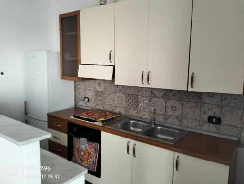 a kitchen with white cabinets and a sink at Casa vacanze da francesca 2 in Realmonte