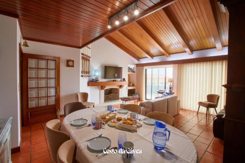 a dining room and living room with a table and chairs at Cesto da Gávea in Praia da Barra