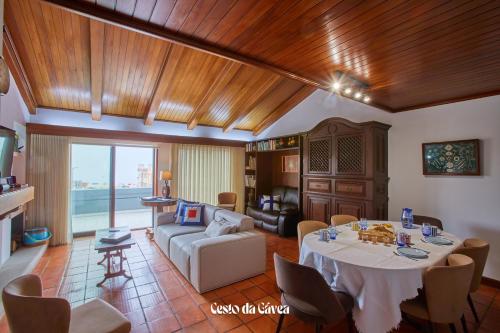 a living room with a table and a couch at Cesto da Gávea in Praia da Barra