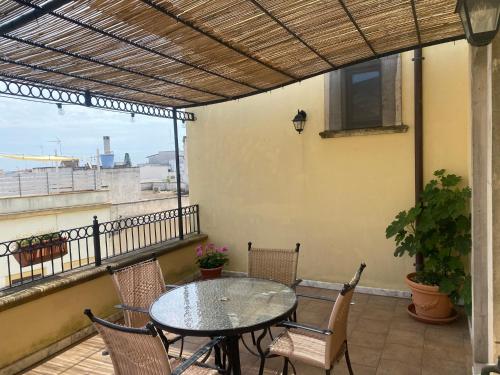 eine Terrasse mit Tisch und Stühlen auf einem Balkon in der Unterkunft B&B Portaterra in Racale