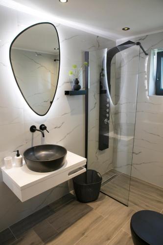 a bathroom with a sink and a mirror at Villa Panorama in Astakos