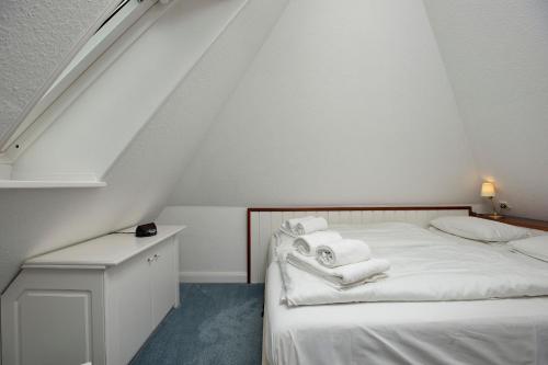 een slaapkamer met een bed met witte handdoeken bij Witt Hingst App 10 in Tinnum