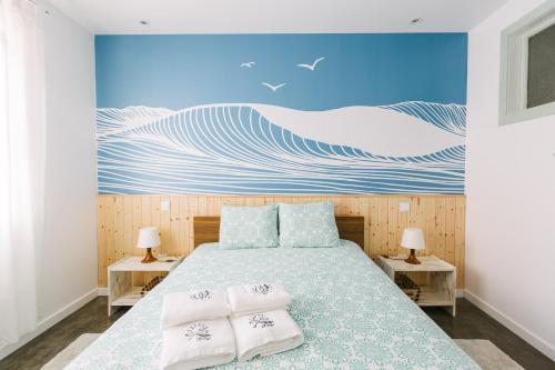 a bedroom with a bed with two pillows on it at Zelitré in Figueira da Foz