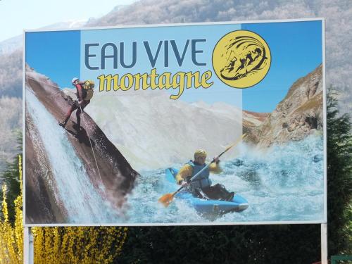 a sign with two people on a paddle board in a river at relais d'isaby in Villelongue