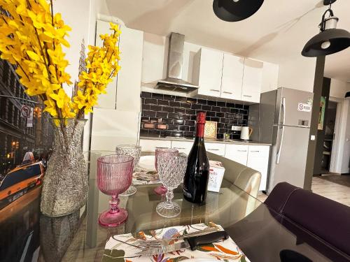 a kitchen with a table with a bottle of wine and glasses at Vitamine Central Apartment in Craiova