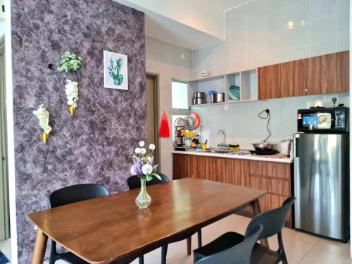 a kitchen with a wooden table and a refrigerator at SweetHome Brinchang Pent House - Pasar Malam area in Brinchang
