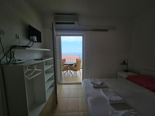 a bedroom with a bed and a view of a patio at Guest house Silvija - sea view in Primošten
