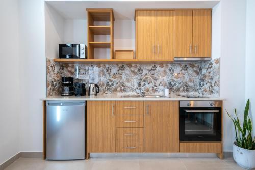 a kitchen with wooden cabinets and a stainless steel refrigerator at Anni Seafront Studios in Plati