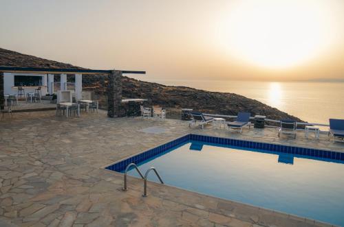 a swimming pool next to a house and the ocean at Cape Napos in Faros