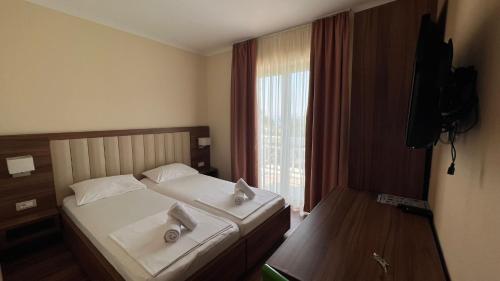 a hotel room with a bed and a window at Villa Gradina in Ba&scaron;ka Voda