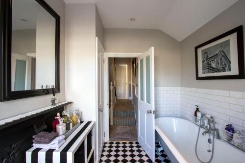 a bathroom with a white tub and a sink at Windsor Road Retreat in Richmond