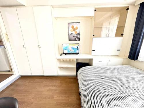 a bedroom with a bed and a desk with a computer at 新宿の宿 in Tokyo