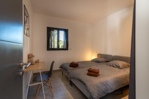 a bedroom with two beds and a table and a desk at Casa Emma in Sollacaro