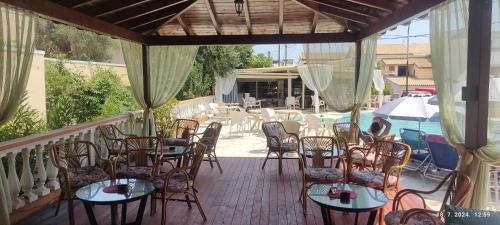 a patio with tables and chairs and a pool at PANTHEON HALL HOTEL in Mesongi