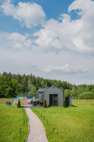 Un pequeño cobertizo en un campo con un camino de grava en KASZUBSKA BALIA DOMEK z BALIĄ NA WYŁĄCZNOŚĆ, en Połęczyno