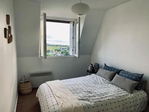 une chambre avec un grand lit avec une fenêtre dans l'établissement Appartement vue mer - plage à pieds, à Blonville-sur-Mer