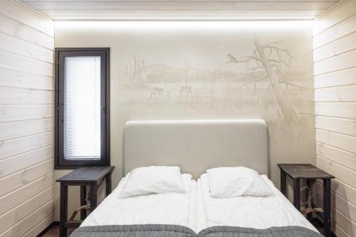 1 dormitorio con 1 cama con 2 mesas y una ventana en Syöte Ski Villa, en Syöte