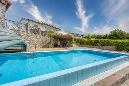 a swimming pool in front of a house at Debeli Rtič Apartments in Ankaran