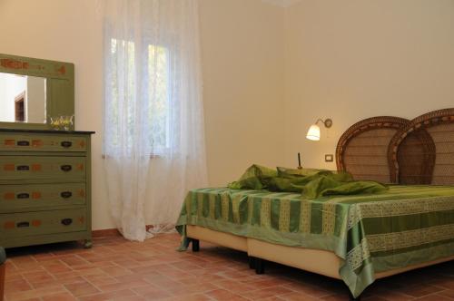 a bedroom with a bed and a dresser and a window at Oasi la Cascata in Le Marmore