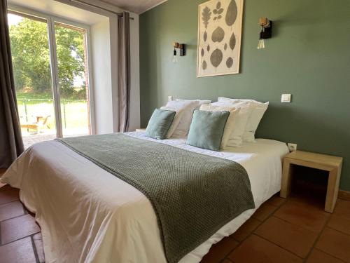 a bedroom with a large bed with a window at La Millière - Piscine & campagne - Céleste in Le Poiré-sur-Vie