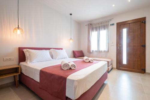 a bedroom with a large bed with towels on it at Anni Seafront Studios in Plati