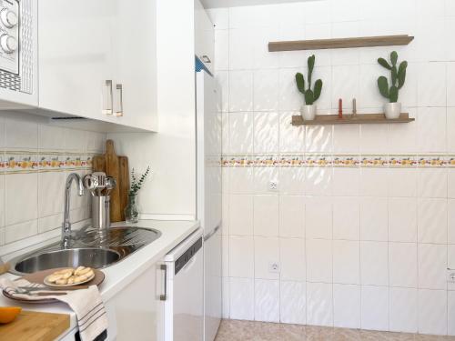 a kitchen with white cabinets and a sink at RosaritoHomes in Madrigal de la Vera