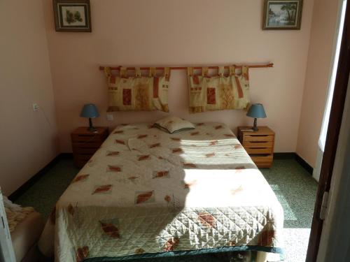 une chambre avec un grand lit et deux lampes dans l'établissement Can Roger, à Argelès-sur-Mer