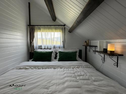 a bedroom with a large white bed with a window at Mounty Nest Fundata in Fundăţica